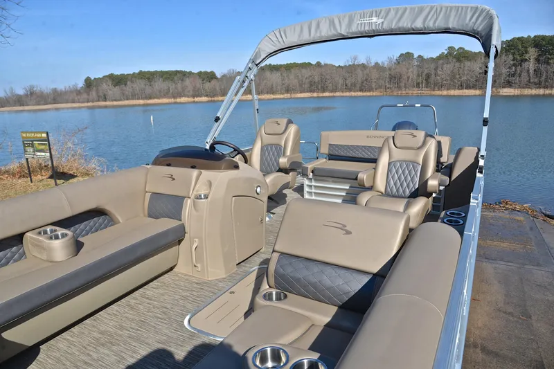 Slide: The Image of 2023 Bennington L23 pontoon boat with luxurious seating on a serene lake. - 22