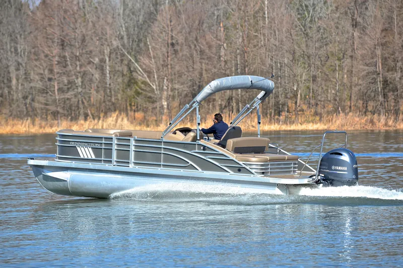 Slide: The Image of 2023 Bennington L23 pontoon boat cruising on a lake with Yamaha engine. - 4