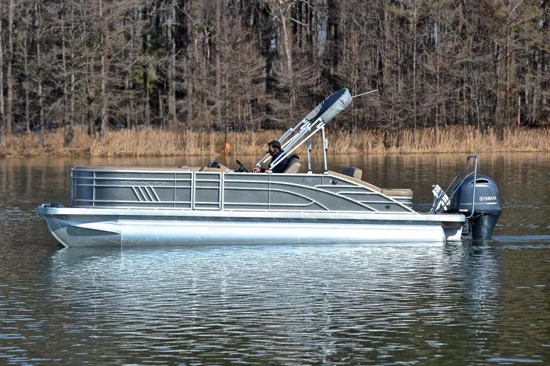 Slide: The Image of 2023 Bennington L23 pontoon boat on a calm lake with Yamaha outboard motor. - 8