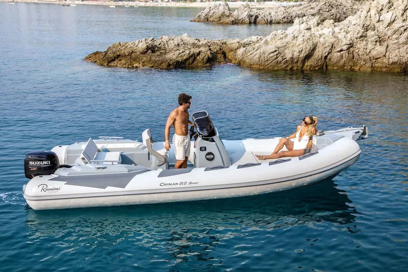 Slide: The Image of 2026 Ranieri Cayman 21.0 Sport boat on clear water near rocky shore. - 4