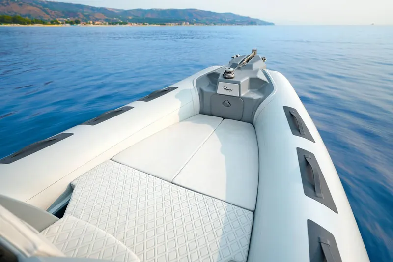 Slide: The Image of 2026 Ranieri Cayman 21.0 Sport boat on calm blue water, scenic coastal view. - 6