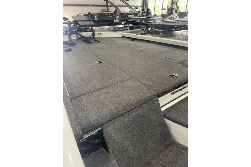 Slide: The Image of 2018 Ranger RT198P boat interior with carpeted deck and storage compartments. - 6