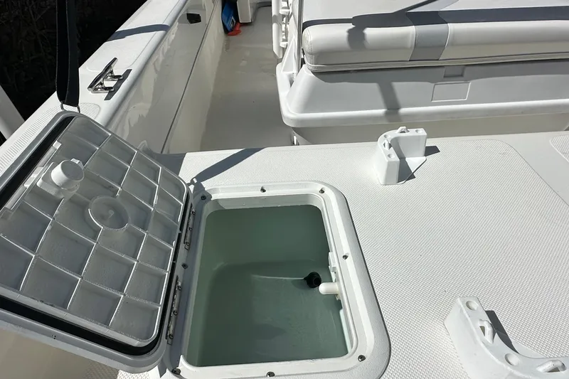 Slide: The Image of Open storage compartment on a 2015 Sundance F19T boat, showcasing interior details. - 11