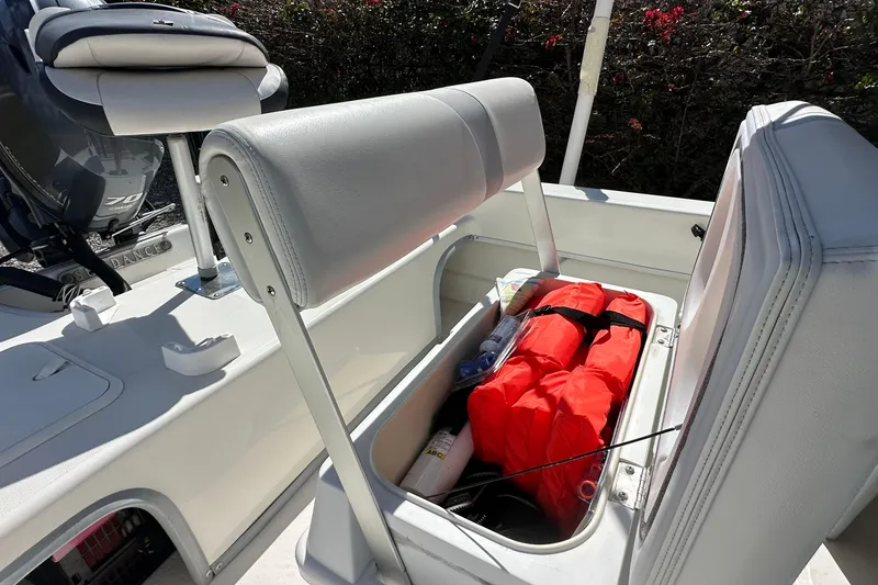 Slide: The Image of 2015 Sundance F19T boat seat storage with life jackets and accessories. - 12