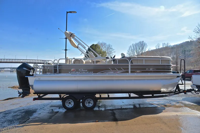 Slide: The Image of 2023 Sun Tracker SportFish 22 XP3 pontoon boat on trailer by the water. - 15