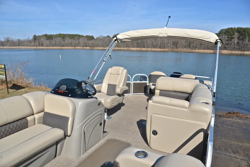 Slide: The Image of 2023 Sun Tracker SportFish 22 XP3 pontoon boat on a serene lake. - 22