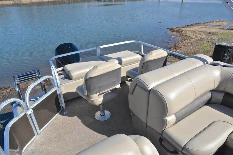 Slide: The Image of 2023 Sun Tracker SportFish 22 XP3 pontoon boat interior with comfortable seating by the water. - 24