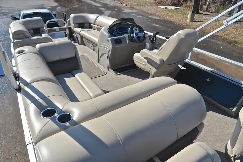 Slide: The Image of 2023 Sun Tracker SportFish 22 XP3 pontoon boat interior with beige seating and steering console. - 25
