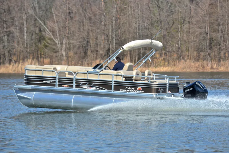 Slide: The Image of 2023 Sun Tracker SportFish 22 XP3 pontoon boat cruising on a lake. - 4