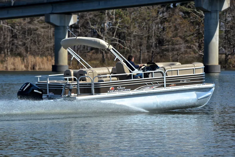 Slide: The Image of 2023 Sun Tracker SportFish 22 XP3 pontoon boat cruising on a calm river. - 5