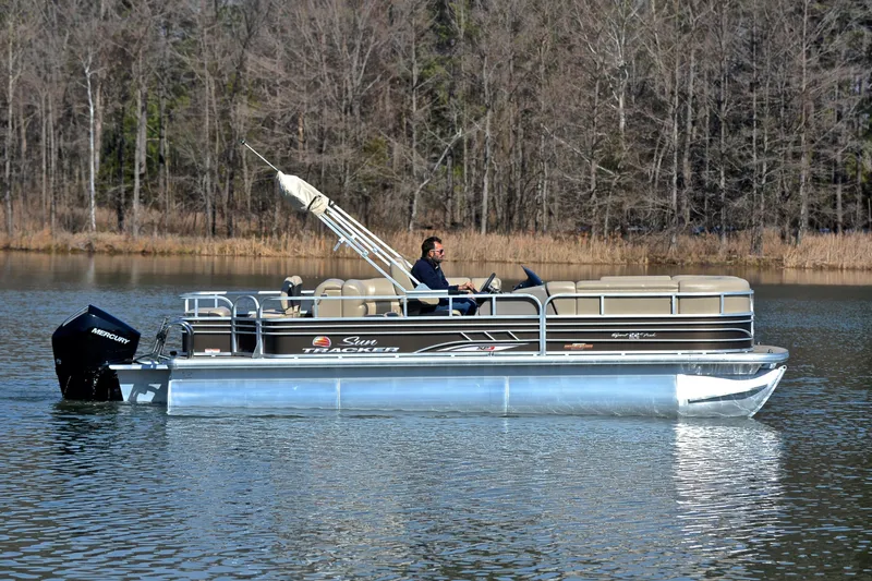Slide: The Image of 2023 Sun Tracker SportFish 22 XP3 pontoon boat on a calm lake. - 6
