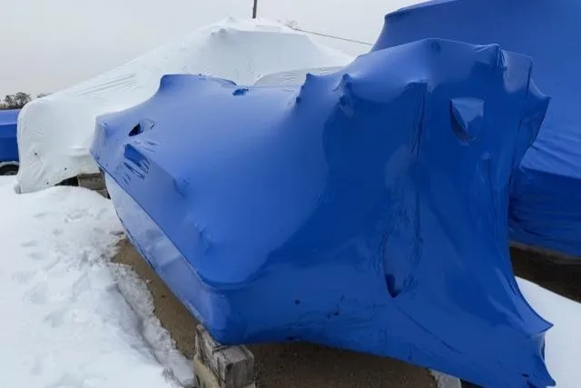 Slide: The Image of 2015 Boston Whaler 180 Dauntless boat covered in blue tarp, winter storage. - 2