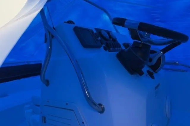 Slide: The Image of 2015 Boston Whaler 180 Dauntless boat console under blue cover. - 3