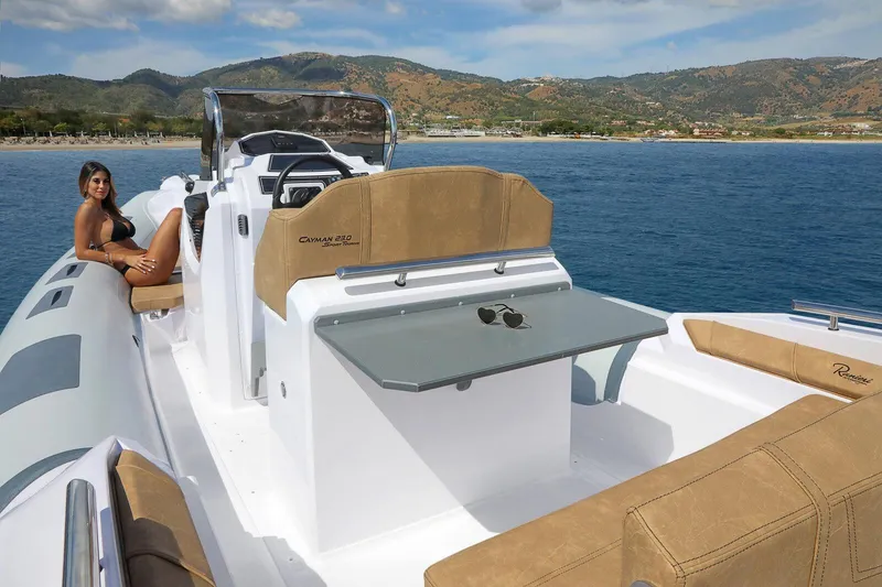 Slide: The Image of 2026 Ranieri Cayman 23.0 Sport Touring boat on water, featuring luxurious seating and scenic backdrop. - 6