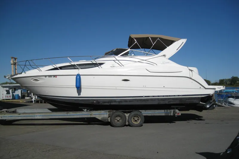 Slide: The Image of 2000 Bayliner 3055 Ciera Sunbridge DX/LX boat on trailer under clear blue sky. - 2