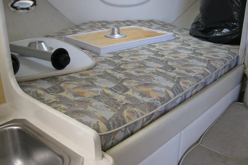 Slide: The Image of 2000 Bayliner 3055 Ciera Sunbridge DX/LX cabin interior with patterned bedding and compact sink. - 20