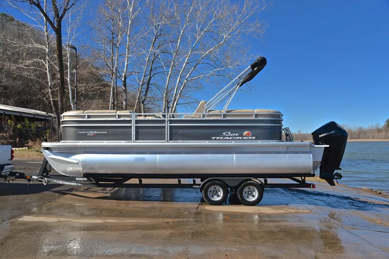 Slide: The Image of 2024 Sun Tracker Party Barge 22 XP3 pontoon boat on trailer by a lake. - 12