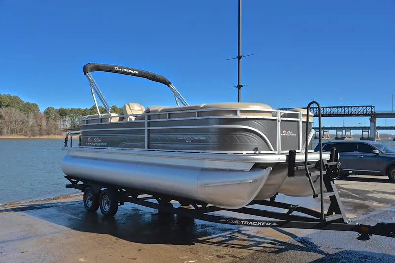 Slide: The Image of 2024 Sun Tracker Party Barge 22 XP3 pontoon boat on trailer by a lake. - 17