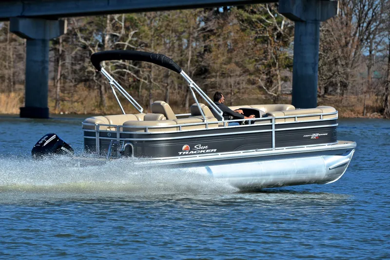 Slide: The Image of 2024 Sun Tracker Party Barge 22 XP3 cruising on a lake under a bridge. - 6