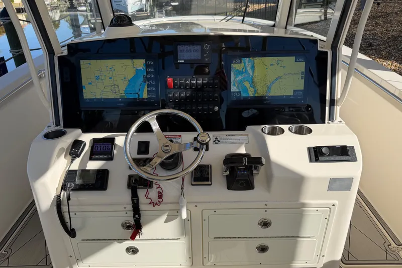 Slide: The Image of 2016 Cobia 344 Center Console helm with dual navigation screens and steering wheel. - 12