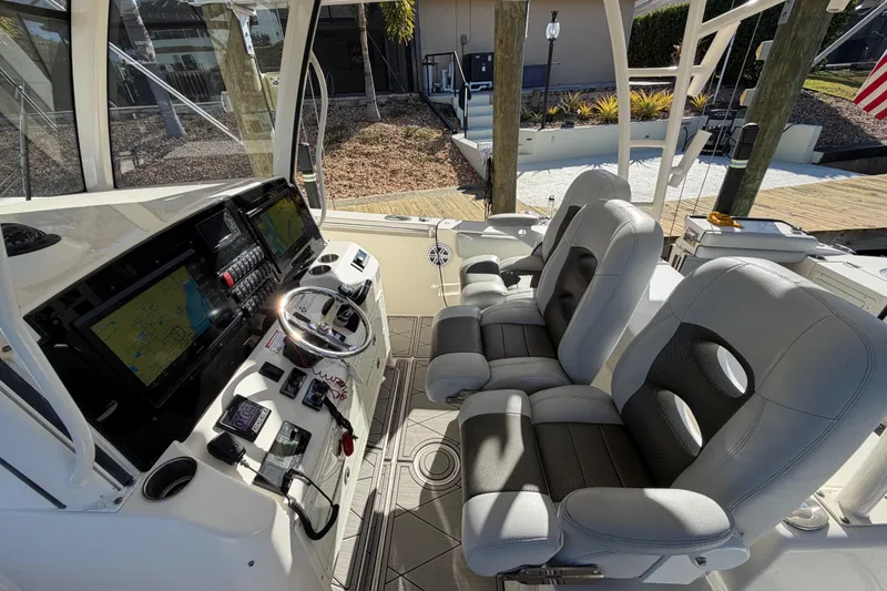 Slide: The Image of 2016 Cobia 344 Center Console boat interior with dual seats and navigation system. - 13