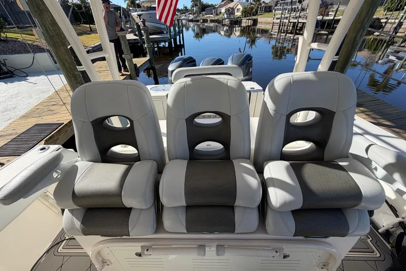Slide: The Image of 2016 Cobia 344 Center Console boat seats by a dockside canal. - 16