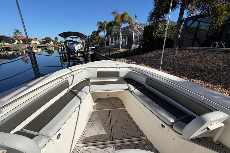 Slide: The Image of 2016 Cobia 344 Center Console boat with spacious seating, docked near waterfront homes. - 24