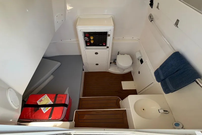 Slide: The Image of 2016 Cobia 344 Center Console interior with toilet, sink, and storage area. - 28