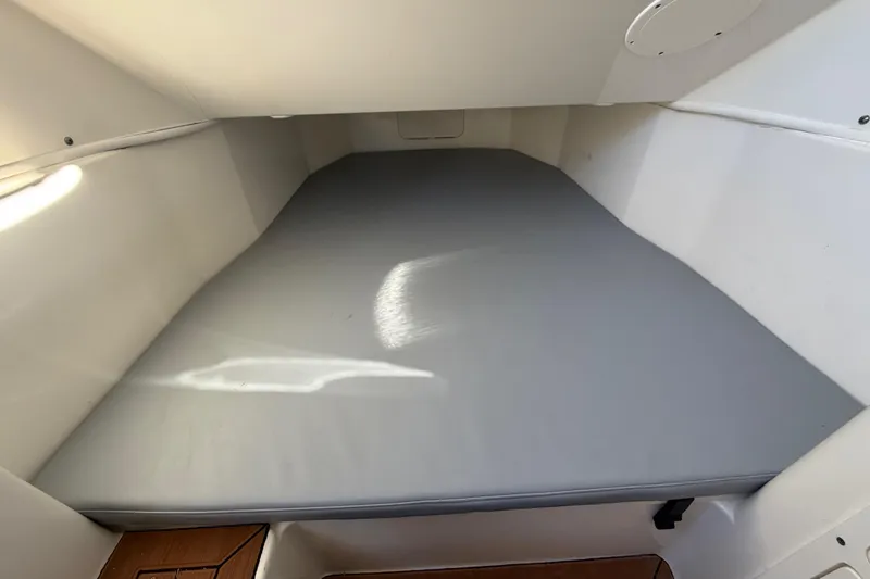 Slide: The Image of 2016 Cobia 344 Center Console cabin interior with cushioned sleeping area. - 30