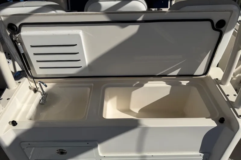 Slide: The Image of 2016 Cobia 344 Center Console boat sink and storage area with open lid. - 32