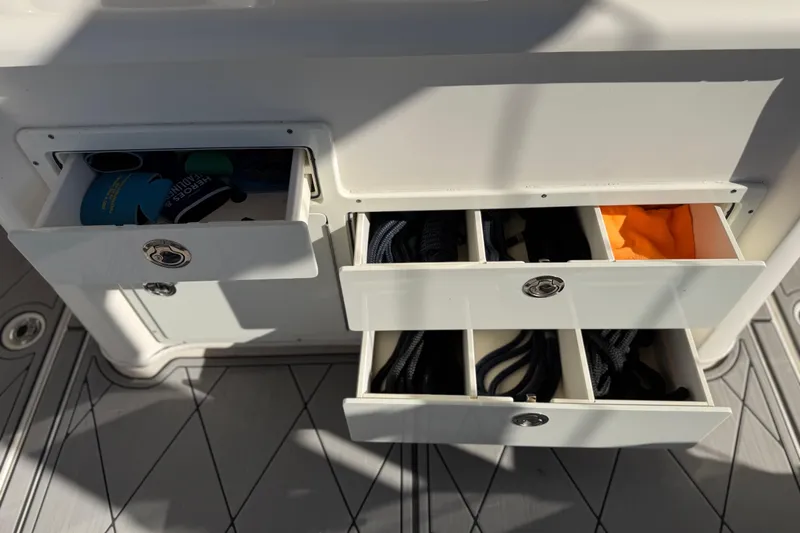 Slide: The Image of Storage compartments on a 2016 Cobia 344 Center Console boat, containing ropes and accessories. - 33