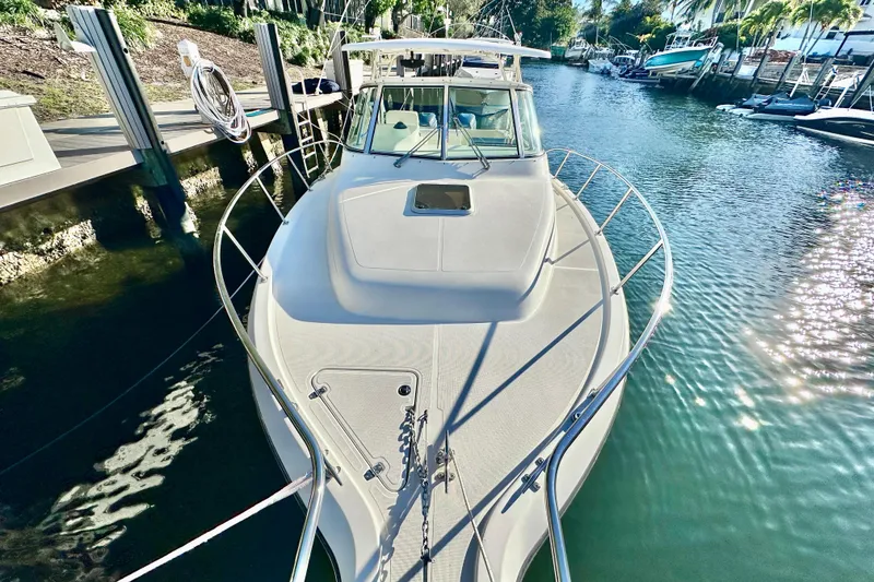 Slide: The Image of 2004 Pursuit 3070 Offshore boat docked in a sunny marina. - 10