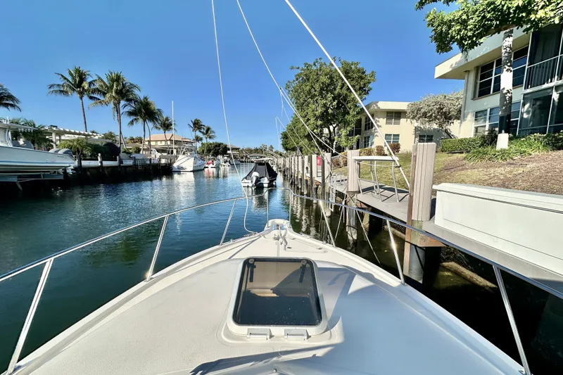 Slide: The Image of 2004 Pursuit 3070 Offshore boat docked in a sunny marina with palm trees. - 11