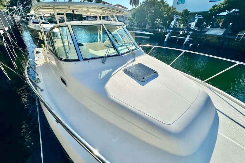 Slide: The Image of 2004 Pursuit 3070 Offshore boat docked in a sunny marina. - 15