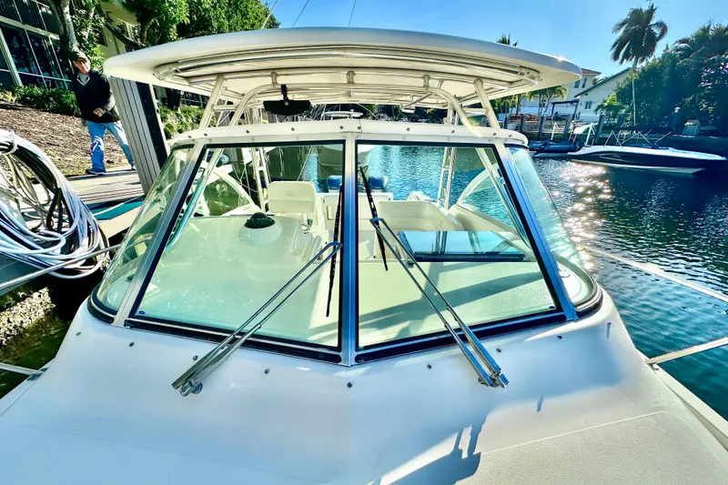 Slide: The Image of 2004 Pursuit 3070 Offshore boat docked by a sunny waterfront. - 16