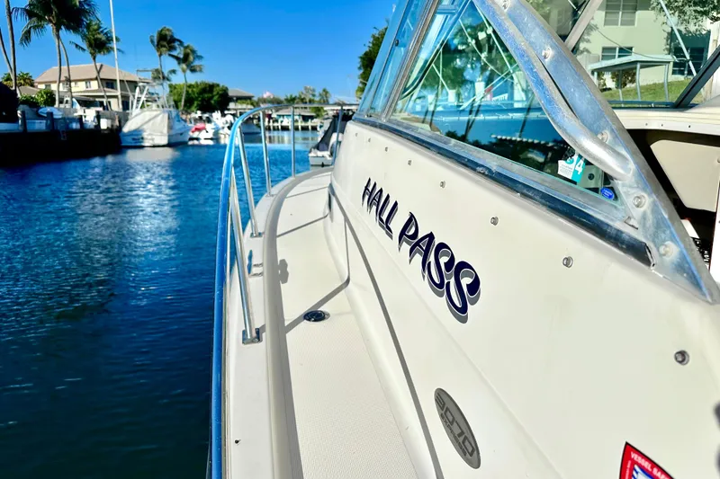 Slide: The Image of 2004 Pursuit 3070 Offshore boat named "Hall Pass" docked in a sunny marina. - 19