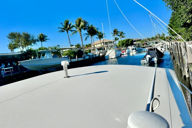Slide: The Image of 2004 Pursuit 3070 Offshore boat docked in a sunny marina with palm trees. - 21