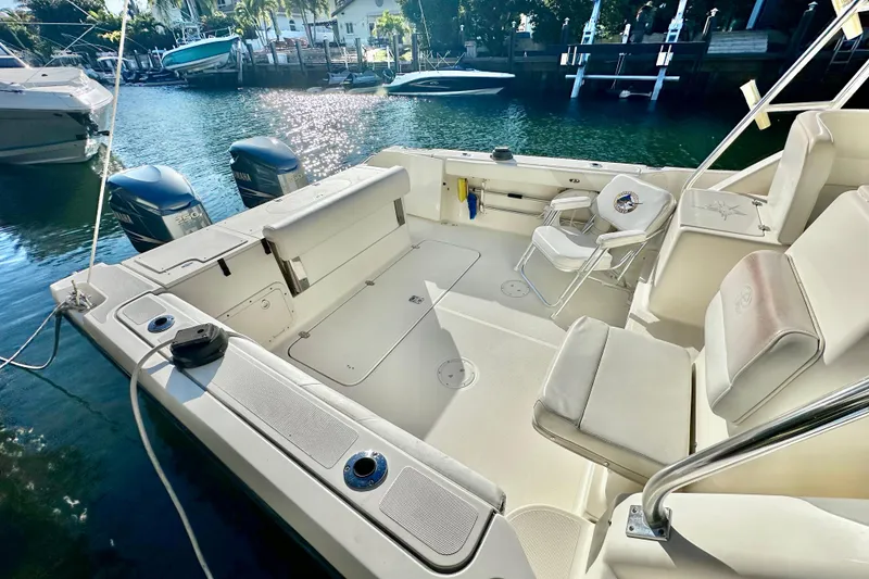 Slide: The Image of 2004 Pursuit 3070 Offshore boat interior with seating and twin Yamaha engines. - 24