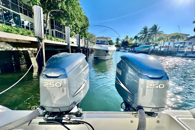 Slide: The Image of Twin Yamaha 250 engines on a 2004 Pursuit 3070 Offshore boat in a sunny marina. - 28
