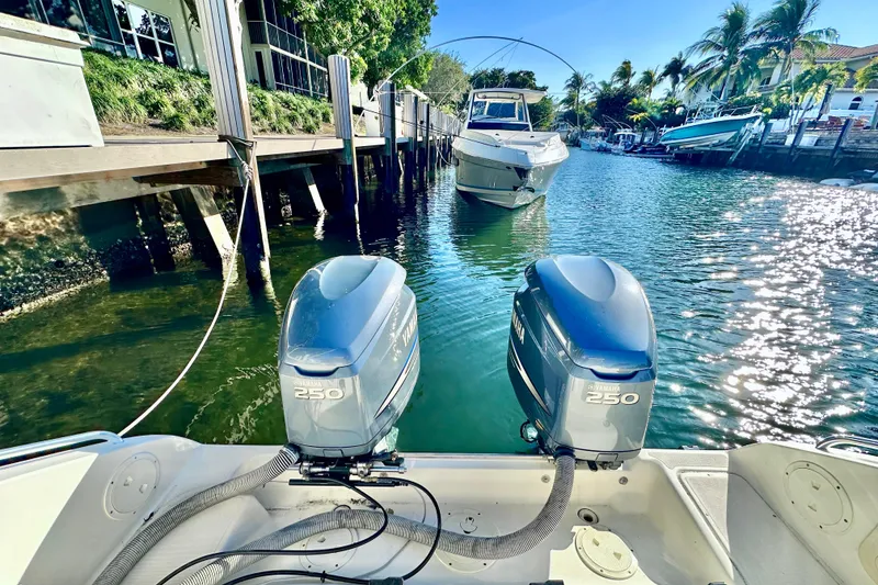 Slide: The Image of 2004 Pursuit 3070 Offshore boat with twin Yamaha 250 engines in a sunny marina. - 30