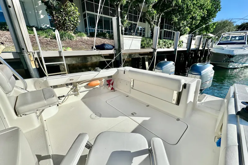 Slide: The Image of 2004 Pursuit 3070 Offshore boat interior with seating and dual Yamaha engines. - 35