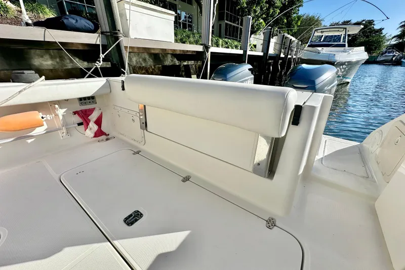 Slide: The Image of 2004 Pursuit 3070 Offshore boat interior with white seating and docked engines. - 36