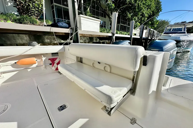 Slide: The Image of 2004 Pursuit 3070 Offshore boat interior with white seating and docked engines. - 37