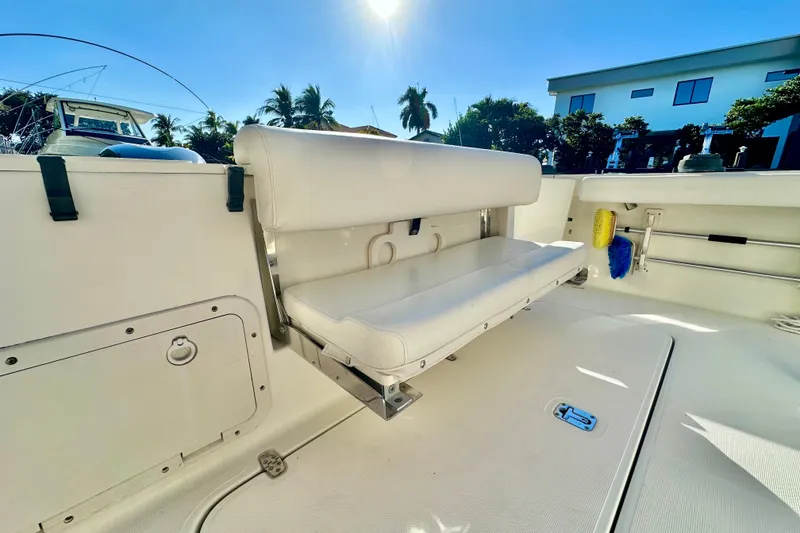 Slide: The Image of 2004 Pursuit 3070 Offshore boat interior with seating, under clear blue sky. - 38