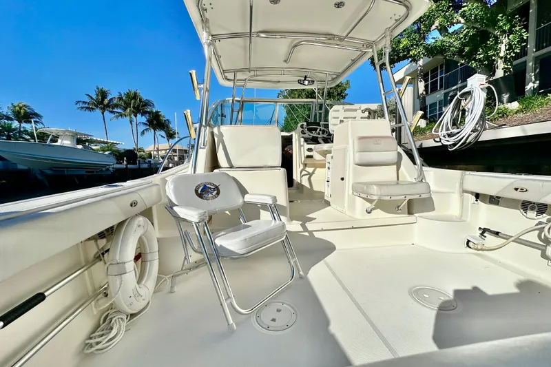 Slide: The Image of 2004 Pursuit 3070 Offshore boat interior with seating, under clear blue sky. - 39