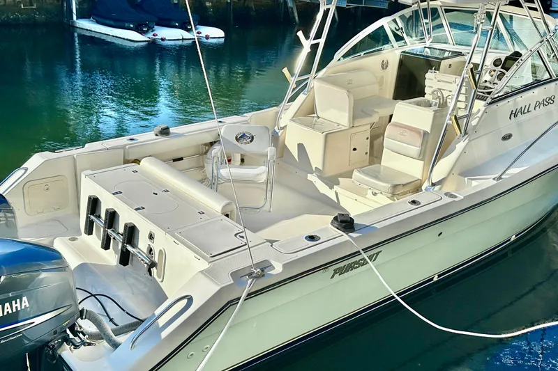 Slide: The Image of 2004 Pursuit 3070 Offshore boat docked, featuring spacious deck and Yamaha engine. - 4