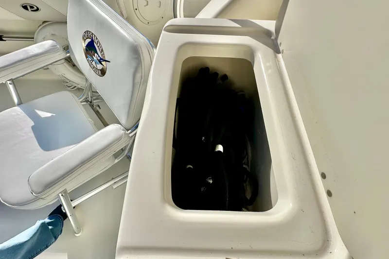 Slide: The Image of 2004 Pursuit 3070 Offshore boat interior with storage compartment and cushioned seat. - 44