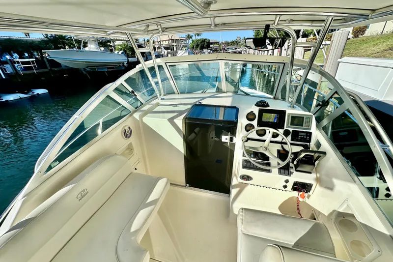 Slide: The Image of 2004 Pursuit 3070 Offshore boat cockpit with steering wheel and navigation equipment. - 52