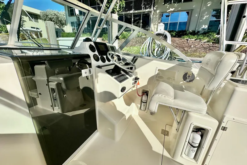 Slide: The Image of 2004 Pursuit 3070 Offshore boat cockpit with steering wheel and seating. - 56