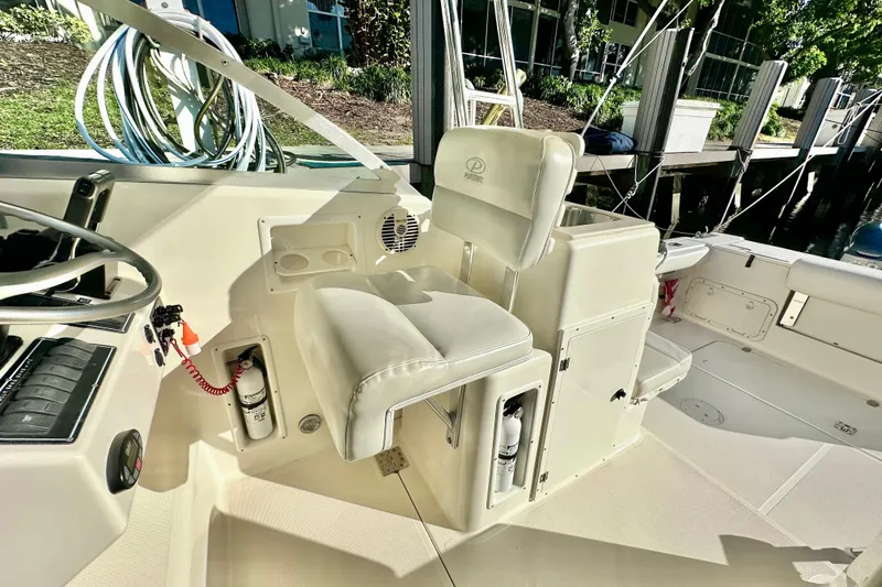 Slide: The Image of 2004 Pursuit 3070 Offshore boat interior with helm seat and control panel. - 57